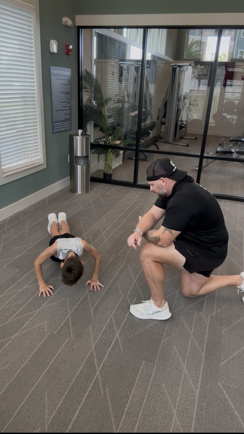 Ryan Hubble providing close coaching during a young athlete’s indoor strength exercise