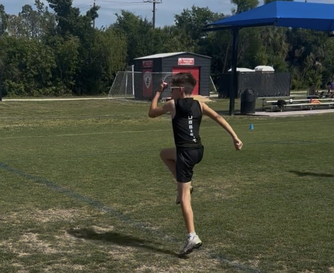 Young Hubb.Fit athlete performing an outdoor speed mechanics drill